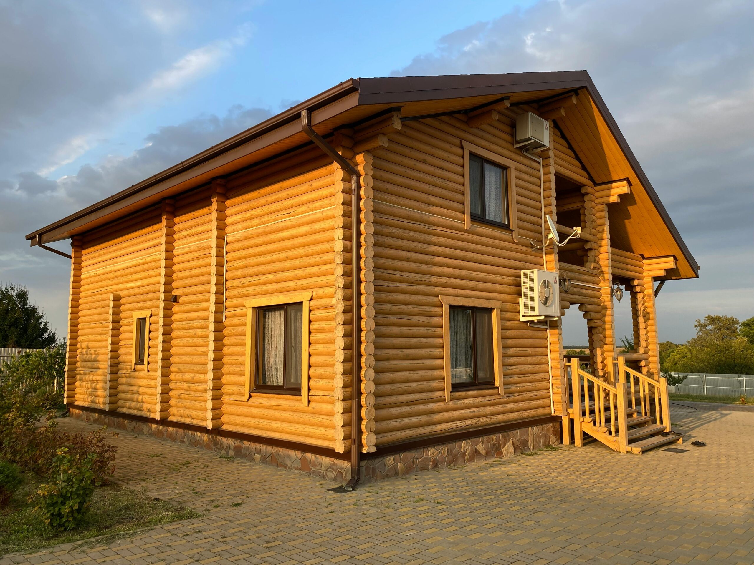 Charming wooden log cabin exterior under a clear blue sky.